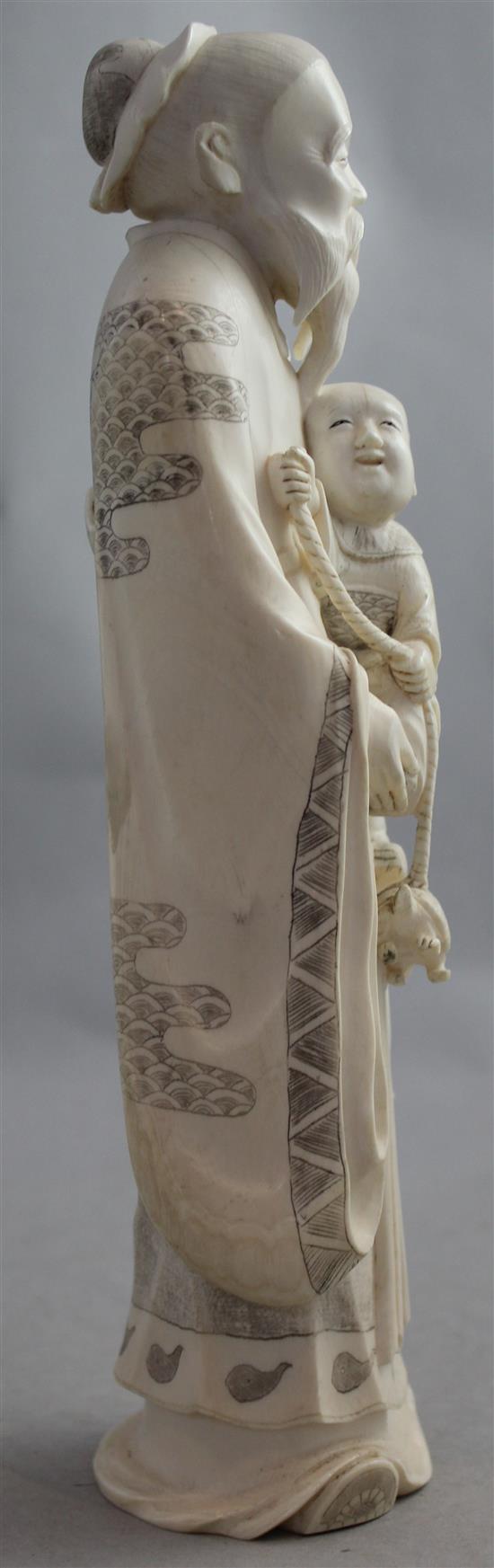 A large Japanese ivory figure of an old man holding a boy, early 20th century, 25.5cm, wood stand